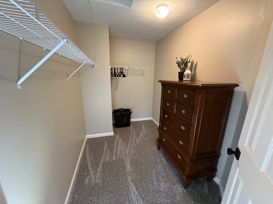 Large walk-in closet in master bedroom with plenty of hanging space and dresser. 