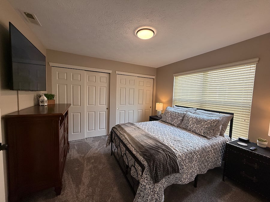 Bedroom with full sized bed, large closet, nightstands, lamps and 55" Roku TV. 