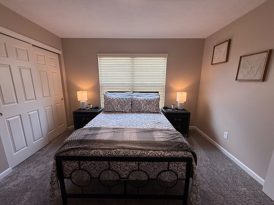 Full size bed with nightstands and lamps. 