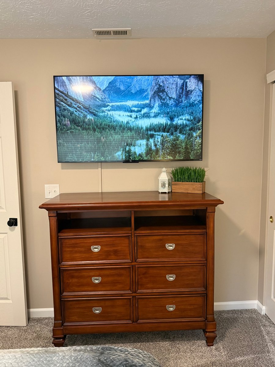 55" TV and dresser in full size bedroom. 