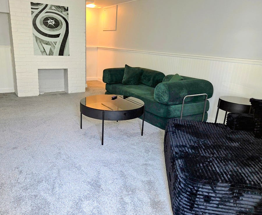 Lounging basement with big screen tv, pull out sofa, and oversized chaise.