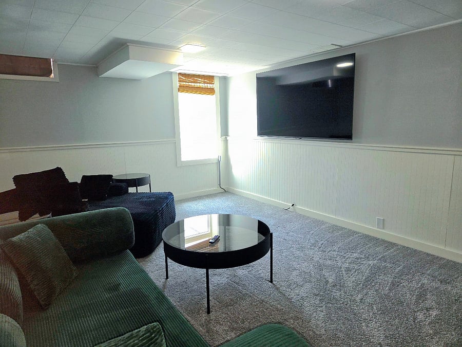 Lounging basement with big screen tv, pull out sofa, and oversized chaise.