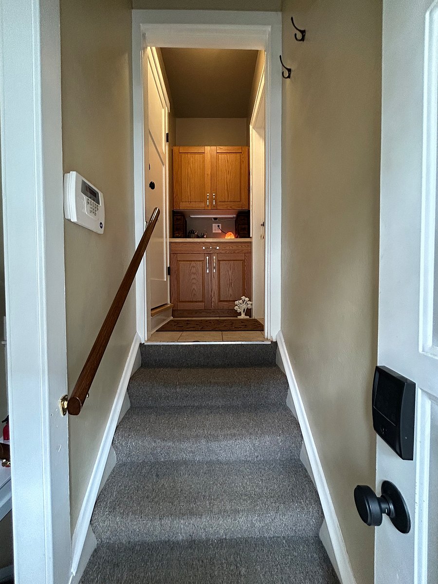 Side entrance with common space stairwell. Up the stairs to the right leads into the dead-bolted private entrance to the 2 BR/1 BA unit.