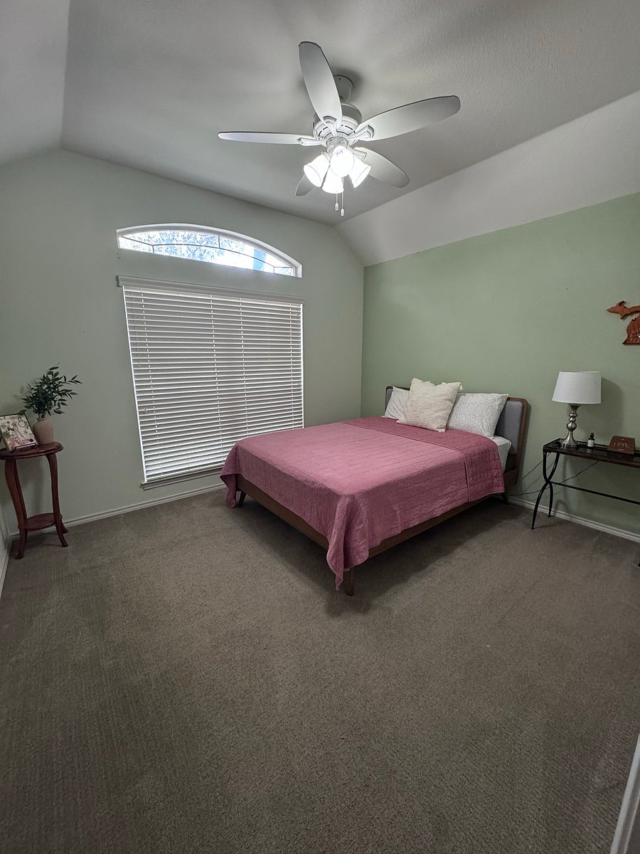 Second bedroom includes: queen sized bed, nightstand, lamp, alarm clock, phone stand, mounted tv, and hanging organizers in the closet.