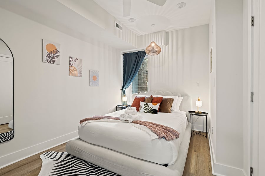 Rest well in a comfortable queen bed with fresh linens, a soft pendant light and blackout curtains, ideal for daytime sleep after overnight shifts.