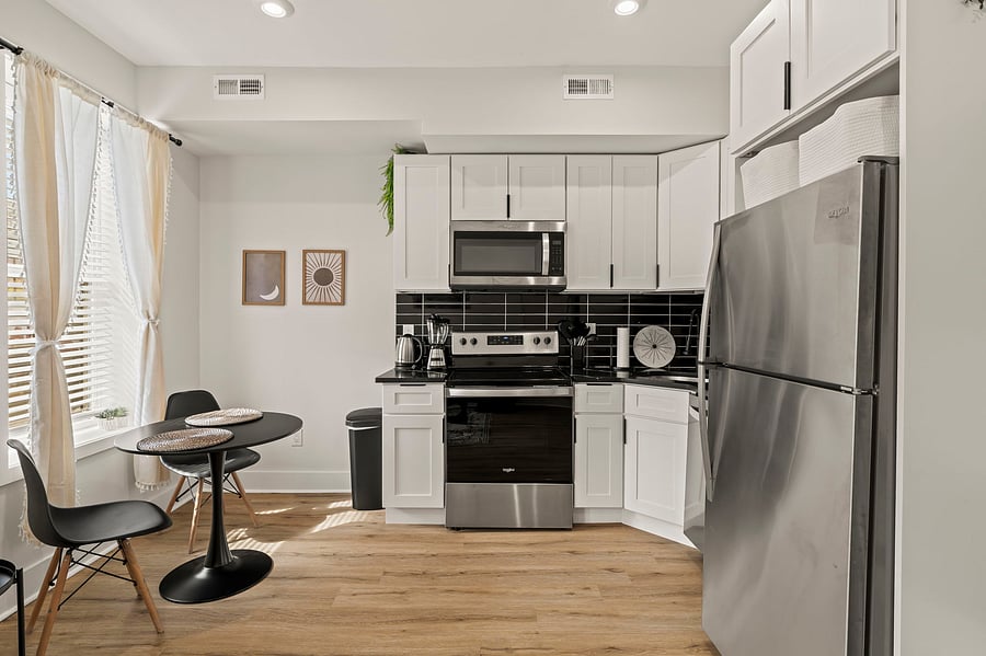 Cook real meals in a full kitchen with stainless appliances and crisp white cabinetry, then enjoy them at your bistro table for two by the window.