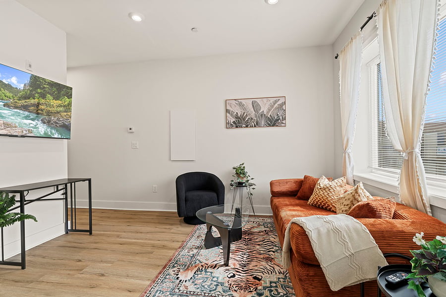 A cozy, well-designed living room with a Smart TV, sofa, accent chair and desk gives you a true home base, not just a place to sleep.