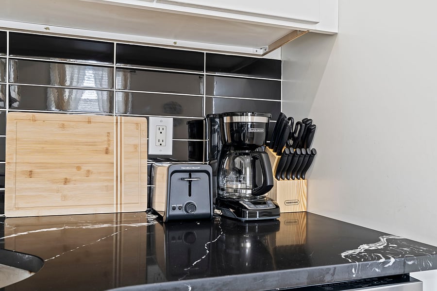 Start every morning right with a coffee maker, toaster, quality knife set and cutting boards, all ready on sleek stone countertops.