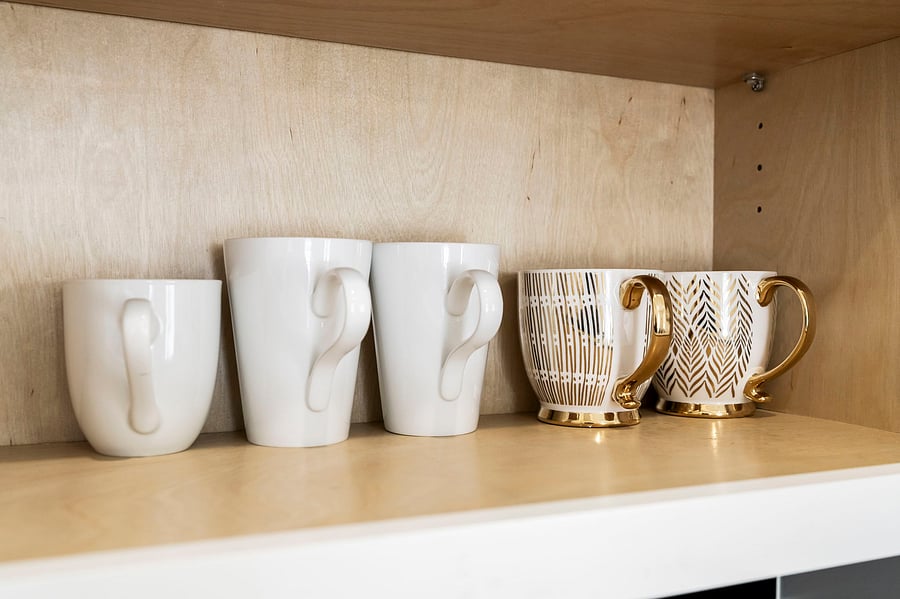 A cabinet of mugs waiting for your morning coffee or late-night tea. Small comforts that make a temporary place feel like yours.