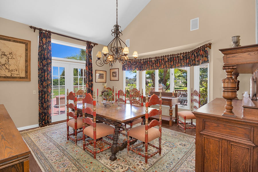 Bright formal dining room with backyard views, offering a spacious setting for meals and everyday living during extended stays.