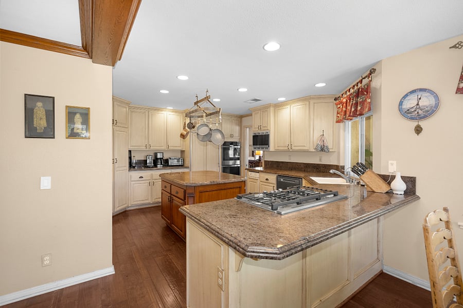 Fully equipped kitchen with generous counter space, center island, gas cooktop, and ample cabinetry, ideal for convenient everyday cooking