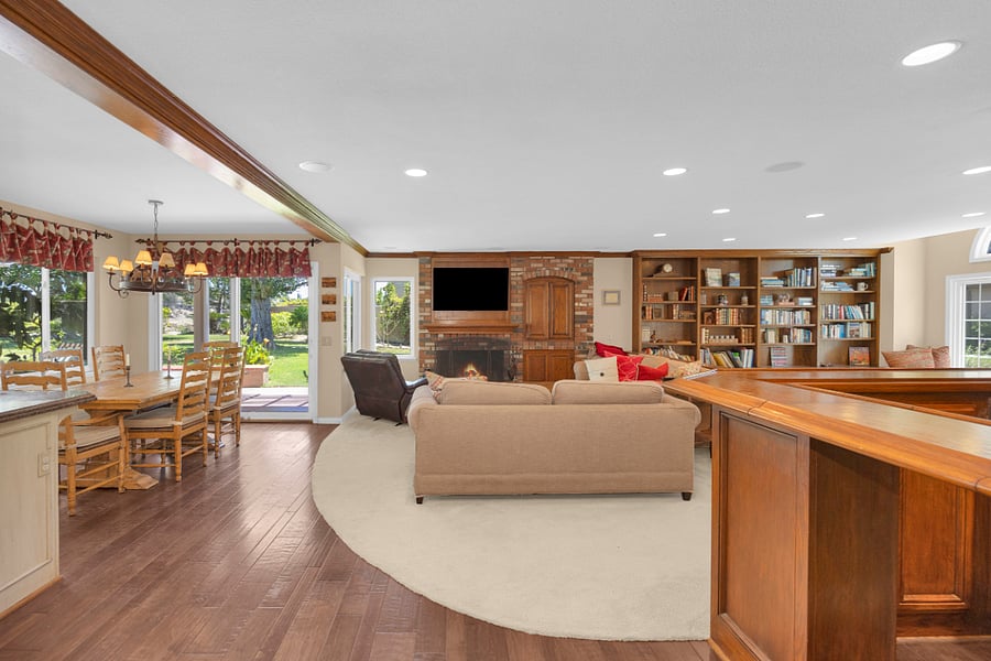 Spacious family room with comfortable seating, fireplace, built-in bookshelves, and an open connection to the kitchen and casual dining area.