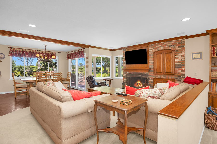 Warm and inviting family room with comfortable seating, fireplace, large TV, and easy access to the backyard and casual dining area.