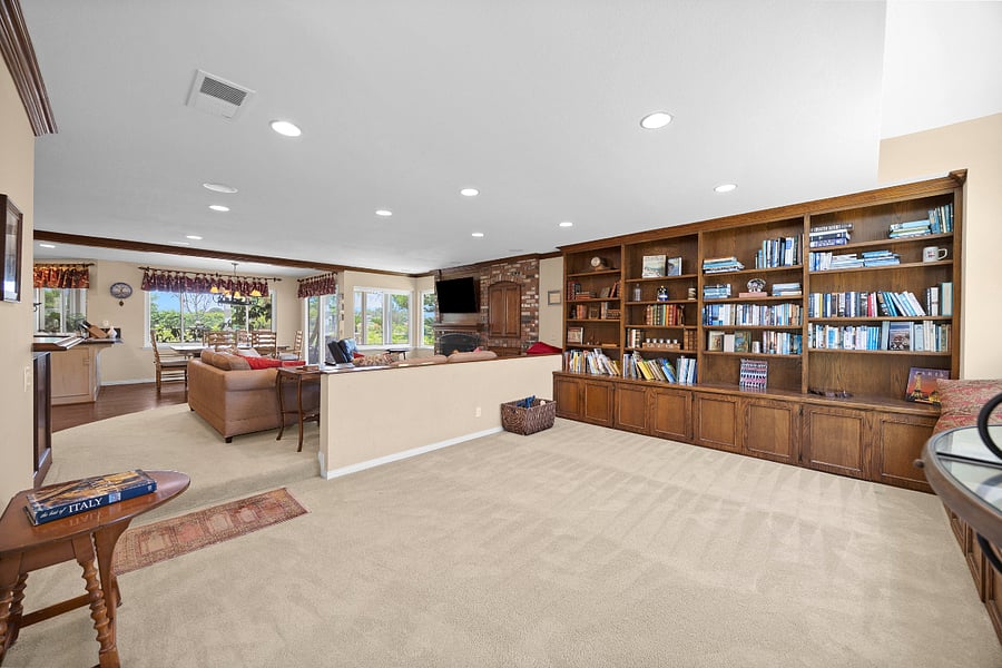 Spacious bonus living area with floor-to-ceiling built-in bookshelves, offering additional room to read, relax, work, or unwind.