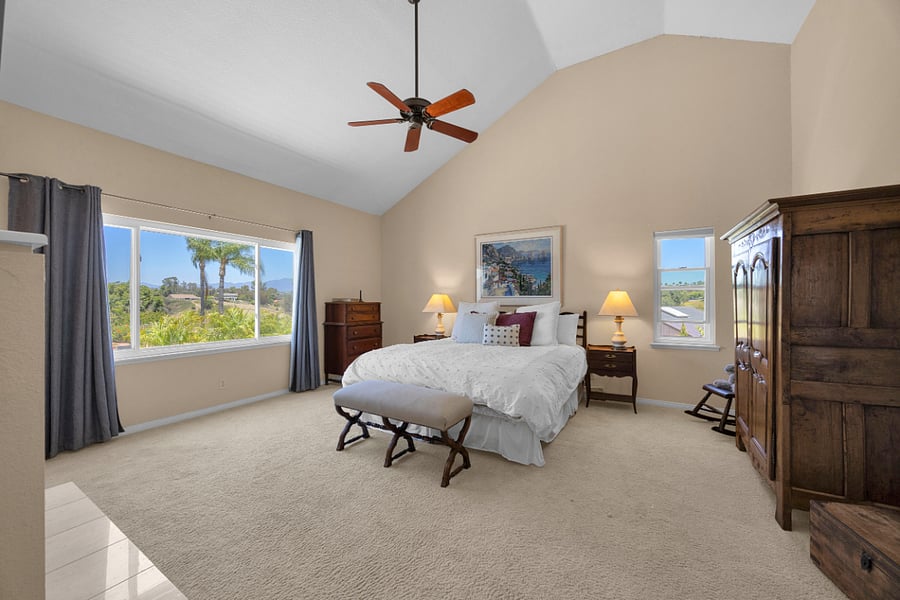 Spacious primary suite with vaulted ceilings, king bed, and beautiful views overlooking the surrounding Nellie Gail Ranch community.