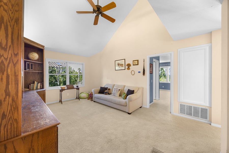 Separate library with vaulted ceilings, comfortable seating, and floor-to-ceiling built-in bookshelves, creating a quiet space to read, work, or unwind.