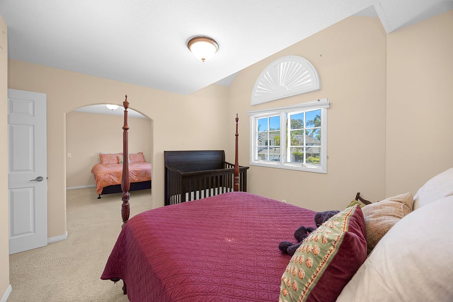 Comfortable full bedroom with plenty of natural light and a crib, offering a welcoming setup for families traveling with little ones.