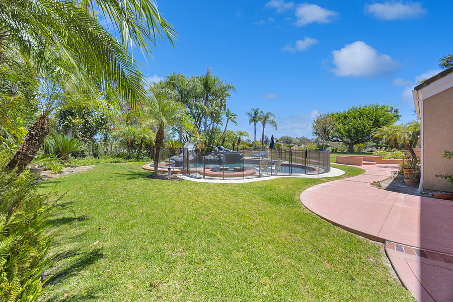 Step outside to your own lush backyard retreat, surrounded by tropical landscaping with a spacious lawn and a private pool and spa at the center of it all.