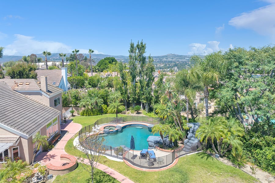 Wake up to sweeping hillside views overlooking your private resort-style backyard, complete with a pool, spa, lush tropical landscaping, and plenty of space to enjoy the Southern California sunshine.