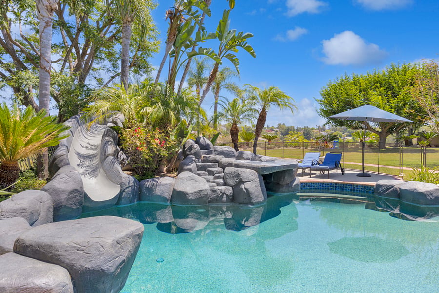 Made for entertaining and enjoying time together, this resort-style backyard offers a private pool, rock waterslide, waterfall, and plenty of space to gather, lounge, and enjoy the California sunshine.
