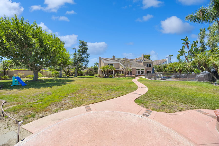 Enjoy a sprawling, park-like backyard with expansive lawns, mature trees, tropical landscaping, and plenty of room to relax, play, and enjoy the Southern California sunshine.