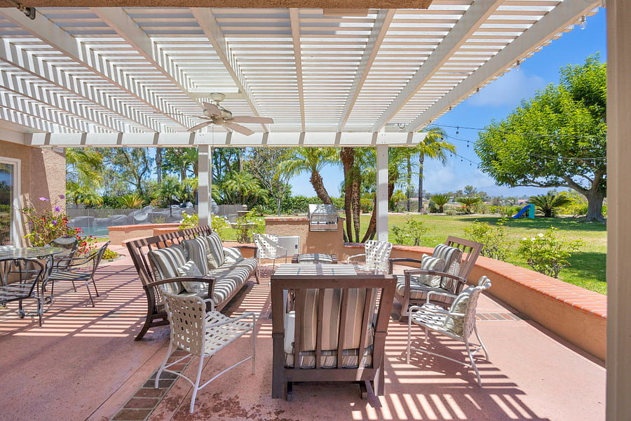 Relax and entertain under the spacious covered patio, with comfortable outdoor seating, a built-in BBQ, and beautiful views across the park-like backyard and pool area.