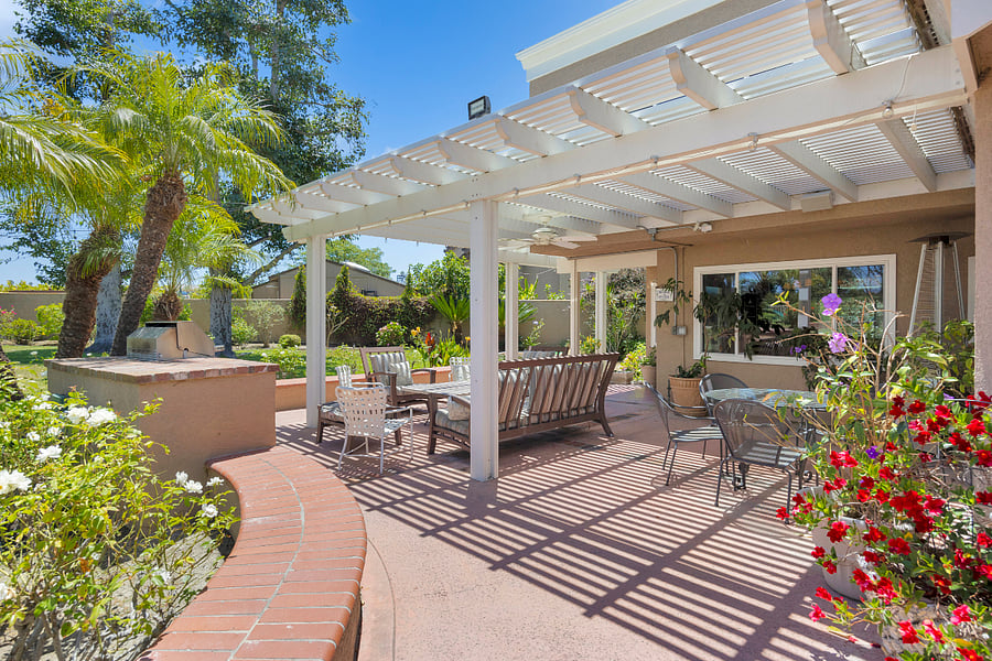 Step outside to a spacious covered patio surrounded by lush landscaping, with plenty of seating and a built-in BBQ for relaxed outdoor dining and entertaining.