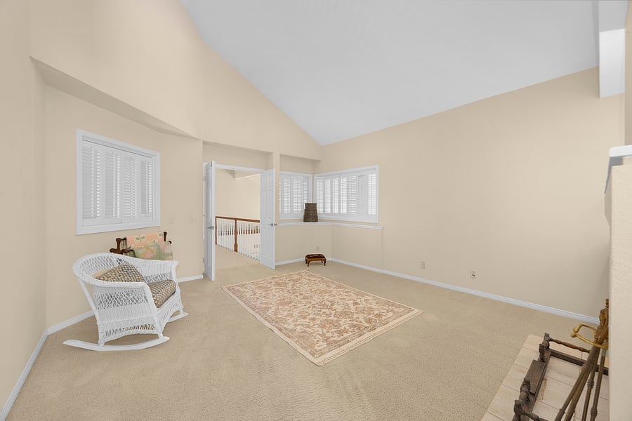 Expansive private sitting room with vaulted ceilings and a cozy two-sided fireplace, creating the perfect retreat within the primary suite.