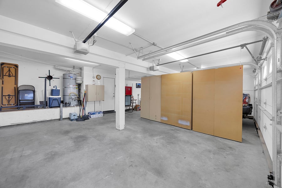 Spacious garage with secure guest parking and additional driveway space for multiple vehicles.