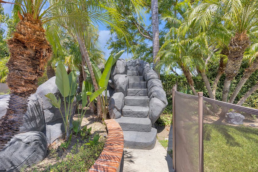 Climb the rock staircase to the exciting waterslide, surrounded by lush tropical landscaping in your private backyard oasis.