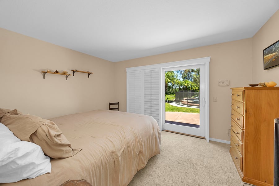Private first-floor guest suite with a California King bed and direct access to the backyard patio.