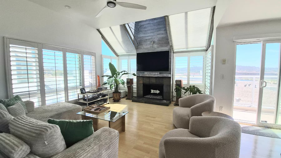 Living room with vaulted ceilings, gas fireplace and smart TV. 