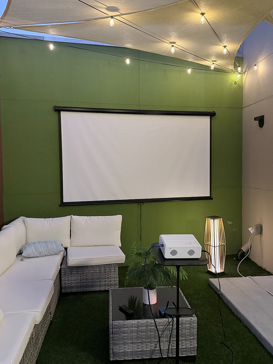 Outdoor projector and lounge seating for movie nights.