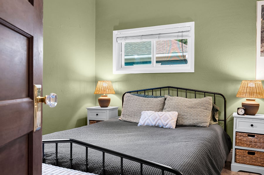 Primary bedroom: two closets, two night stands with lamps and storage, two hooks, queen size bed and footlocker storage at the end of the bed.