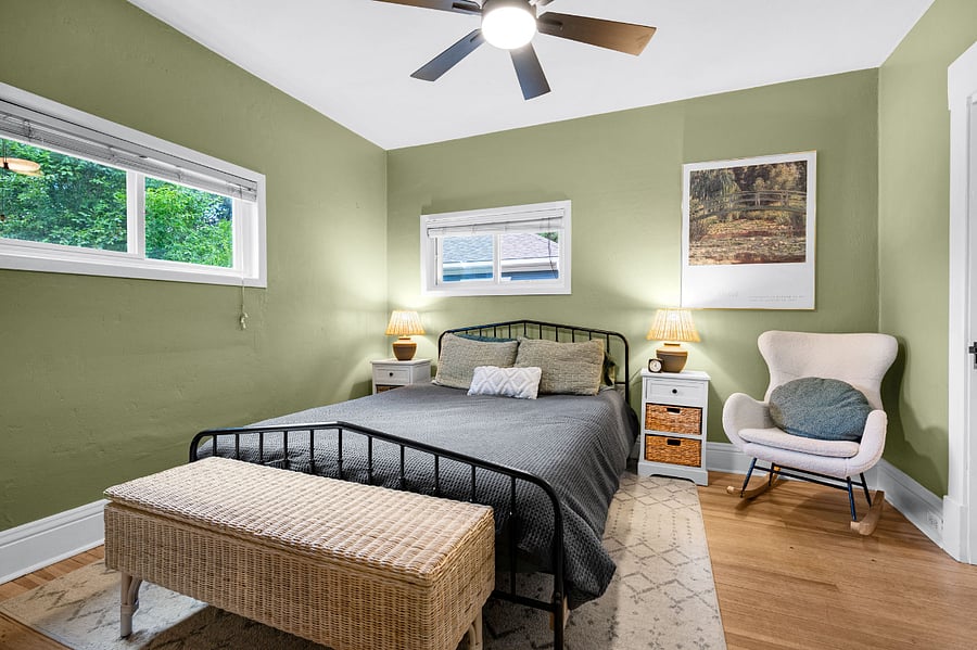Primary bedroom: two closets, two night stands with lamps and storage, two hooks, queen size bed and footlocker storage at the end of the bed.