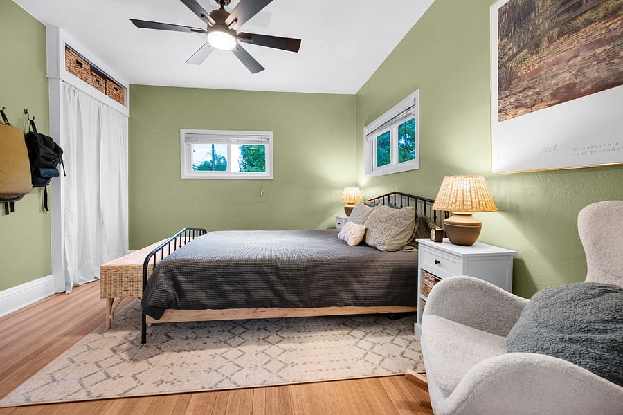 Primary bedroom: two closets, two night stands with lamps and storage, two hooks, queen size bed and footlocker storage at the end of the bed.