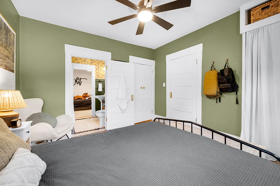 Primary bedroom: two closets, two night stands with lamps and storage, two hooks, queen size bed and footlocker storage at the end of the bed.