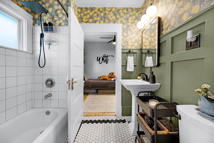 Bathroom (jack-and-jill style between both bedrooms) has a toilet, sink, built-in medicine cabinets, built in shelving (next to the shower), shower/tub and storage cart.