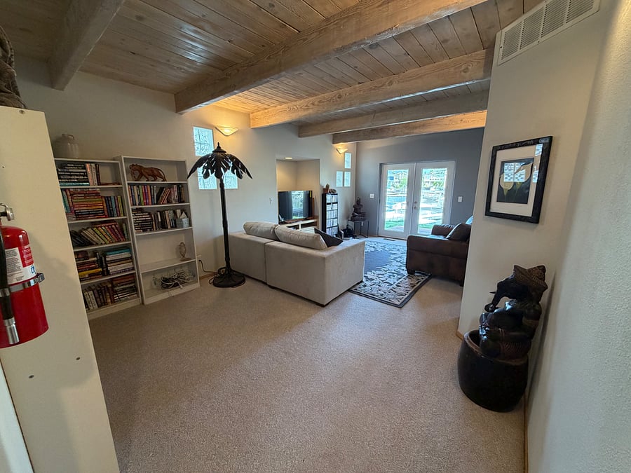 downstairs den with loads of books, smart tv, dvd player and dvds, leads out to backyard and dock, with beautiful over the water deck