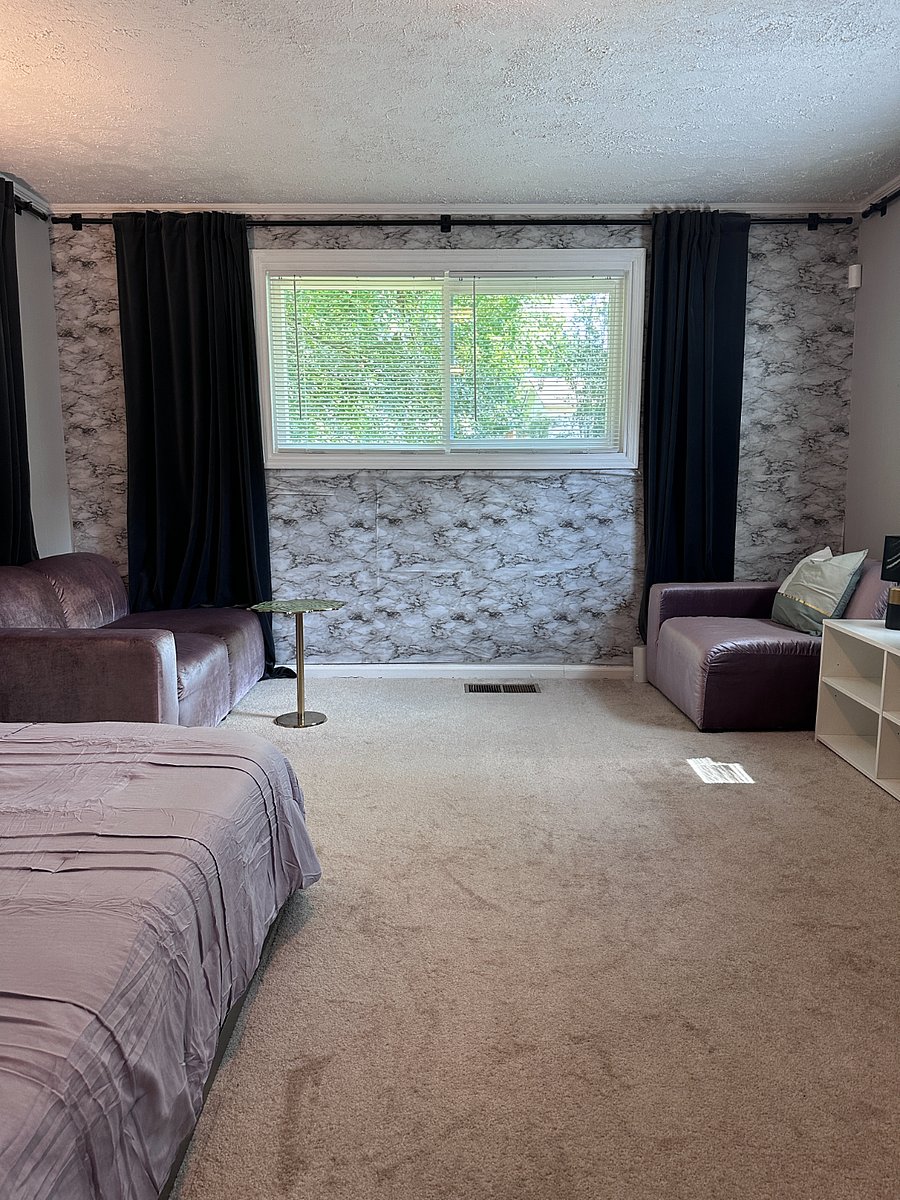 Primary bedroom with queen sized bed, seating area, and direct access to backyard (not pictured)