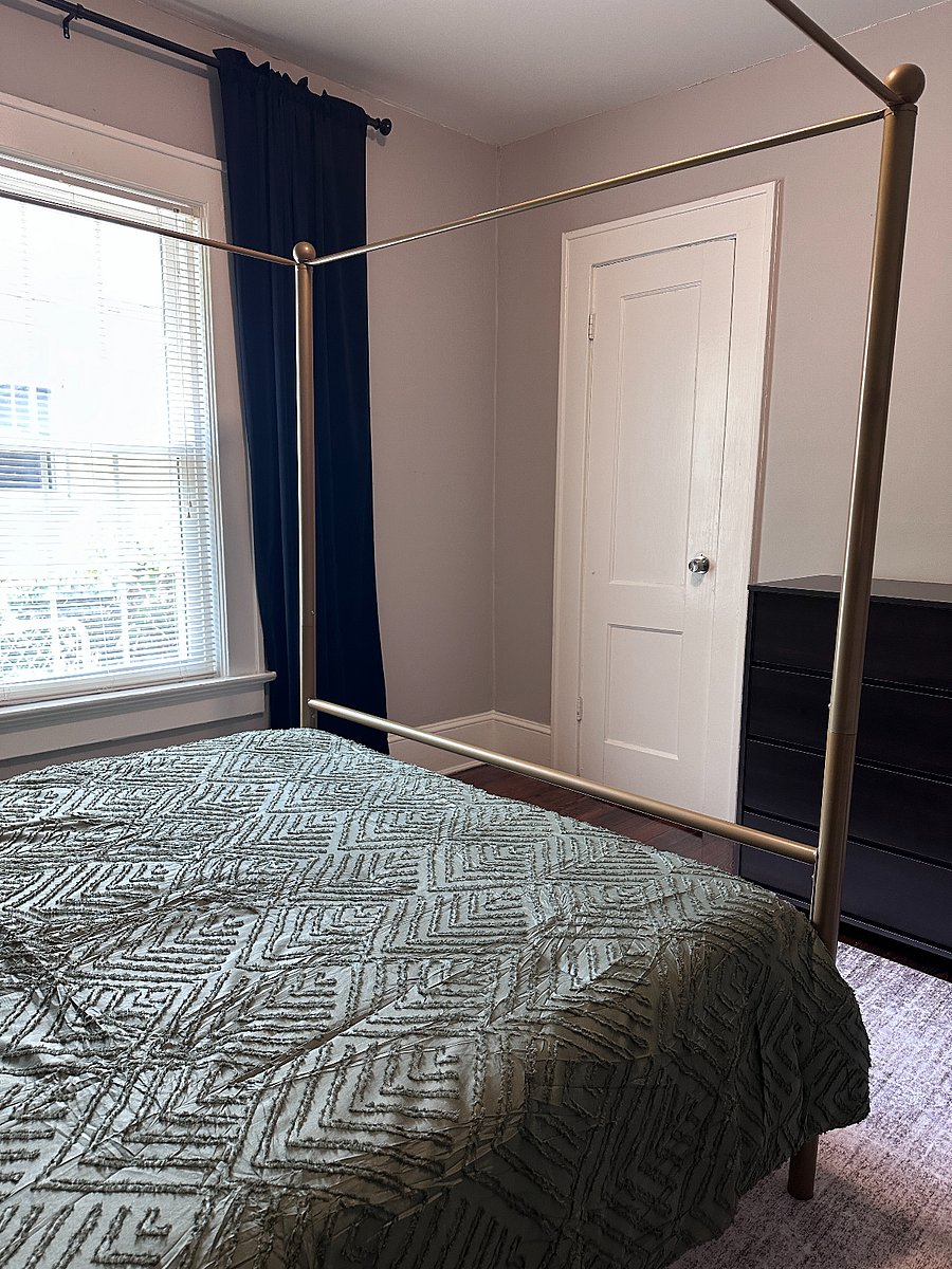 Secondary bedroom with queen sized bed, dresser, and closet