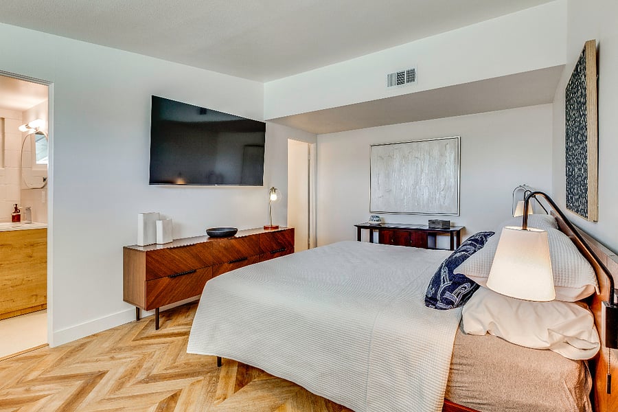Primary bedroom View 1 with King Bed, 65" tv, ensuite bathroom and blackout blinds. Primary bedroom is segregated from guest bedroom for privacy.