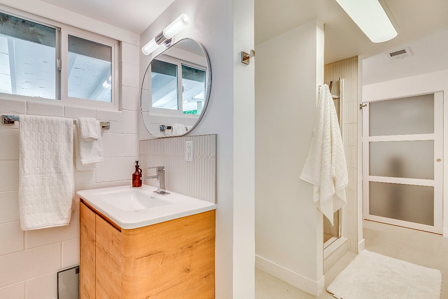 Primary ensuite bathrooom with segregated dual vanities and closets with shower stall.