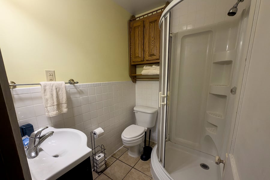The second full bathroom walk-in shower, subway tile, and cabinet storage. Everything you need, nothing you don't.