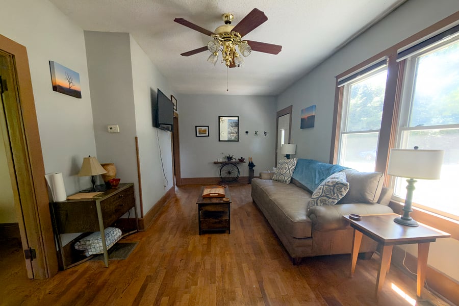 The full living room high ceilings, mounted smart TV, original hardwood floors, and enough natural light that you'll rarely need to flip a switch before dark.