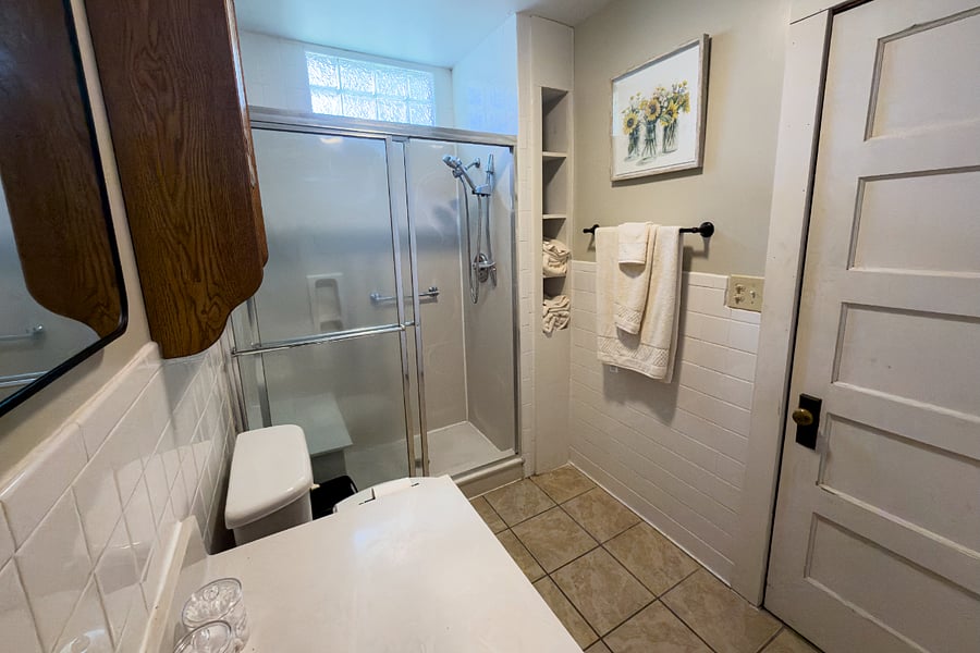 The en suite master bath glass shower with a bench seat, built-in shelving, subway tile, and enough counter space to actually spread out. Everything you need after a long day on the trail.