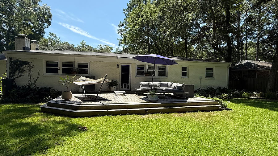 View of deck with grill, umbrella, hammock, couch, Storage box, and picnic table.