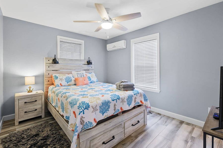 Guest bedroom with queen bed.  There is a walk-in closet with shelves, drawers and bar for hanging clothes.
