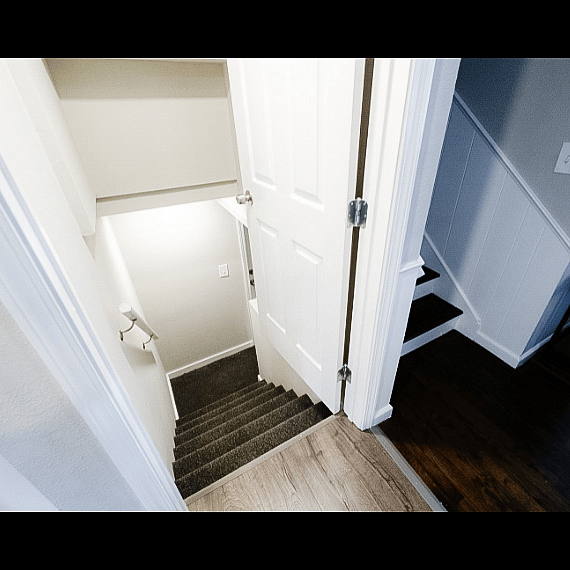 Stairway to basement area that includes bedrm, bath and W/D