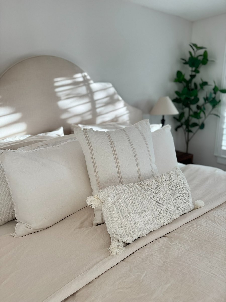 Bright and airy primary bedroom with modern furnishings, a comfortable king mattress, and plantation shutters for a restful night's sleep. Includes an en-suite bath and walk-in closet.